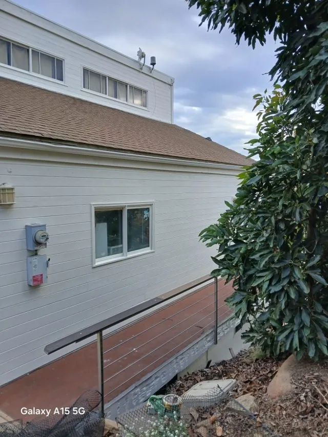 Professional power washing of a home exterior before painting